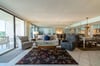 The great room is furnished in a coastal casual style with a queen sized sofa sleeper, swivel tub chair, and a recliner