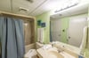 The Tennis View Suite's bathroom has a tub/shower combo, a single vanity and a toilet. It also opens to the hallway for use by guests using the sleeper sofa.