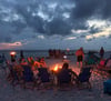 Gather friends and family around a beach bonfire
